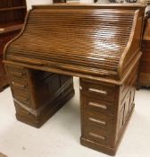 An early 20th Century oak tambour top desk,