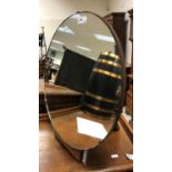 An early to mid 20th Century circular dressing mirror on an adjustable oak base with ratchet easel