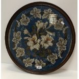 A framed and glazed beadwork panel, the blue ground set with floral sprays,