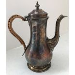 A George III silver coffee pot of baluster form with caned handle and raised on circular stepped