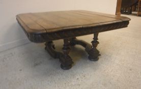 An early 20th Century French walnut rounded rectangular coffee table on four column supports united