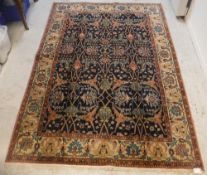 A Persian rug, the central panel set with stylised foliate decoration on a dark blue ground,