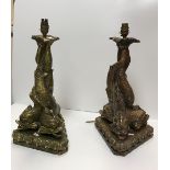 A pair of gilded plaster table lamps as entwined dolphins on shell bases approx.