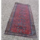 A Hamadan runner, the central panel set with repeating design on a red ground,
