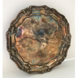 A William IV silver salver of nine sided form with pie crust and acanthus decorated rim raised on