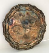 A William IV silver salver of nine sided form with pie crust and acanthus decorated rim raised on