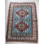 A Persian rug with two repeating elephant foot medallions on a turquoise ground within a brown,