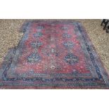 A Persian rug with all over floral medallion decoration on a plum ground,