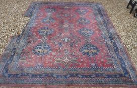 A Persian rug with all over floral medallion decoration on a plum ground,