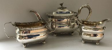 A late George III silver three piece tea set of square form with egg and dart and shell decorated