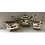 A late George III silver three piece tea set of square form with egg and dart and shell decorated