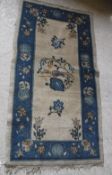 A circa 1920's Chinese carpet, the central panel set with bird and foliate motif on a cream ground,