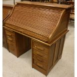 An early 20th Century oak tambour top desk,