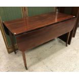 An early 19th Century mahogany drop-leaf Pembroke style dining table on square tapered legs to