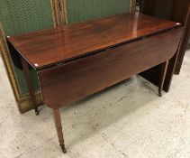 An early 19th Century mahogany drop-leaf Pembroke style dining table on square tapered legs to