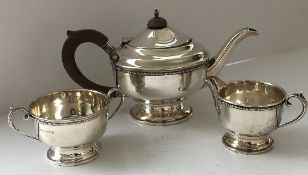 A George V silver tea set with beaded decoration raised on a circular foot (Birmingham 1933 by