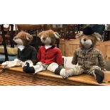 A set of three door stops as foxes in hunting attire,