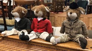 A set of three door stops as foxes in hunting attire,