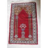 A Bokhara rug the central panel set with Mirhab style design on a red ground within a stepped red,