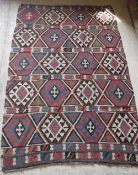 A Caucasian tribal kelim with five bands of lozenge medallions in dark brown, blue, red and cream,