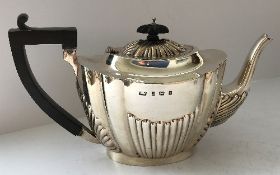 An Edwardian silver teapot with fluted decoration (by Thomas Wilkinson & Sons, Birmingham 1903),