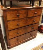 A Victorian mahogany chest of two short over three long drawers with turned knob handles raised on