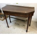 A 19th Century mahogany fold over tea table in the George III taste raised on square tapered legs