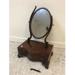 A 20th Century mahogany serpentine fronted toilet mirror with oval plate,