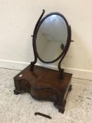 A 20th Century mahogany serpentine fronted toilet mirror with oval plate,