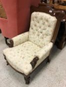 A Victorian mahogany framed salon armchair on carved and turned front legs to casters 96 cm high by