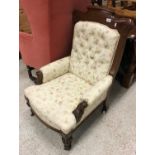 A Victorian mahogany framed salon armchair on carved and turned front legs to casters 96 cm high by