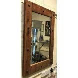A modern Indian wooden wall mirror with large metal stud work decoration,