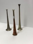Three metal hunting horns of various sizes