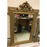 Two French Henry V style giltwood and gesso framed wall mirrors with scrollwork decorated surmounts,