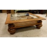 A mid 20th Century mahogany framed glass top coffee table on heavy baluster turned squat supports