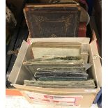 A box containing assorted Victorian and later postcards and photo albums to include postcards of