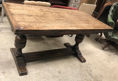 An oak draw leaf dining table in the 16th Century style, the plain top with cleated ends,