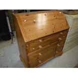 A modern pitch pine bureau, the sloping fall above one long,