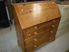A modern pitch pine bureau, the sloping fall above one long,