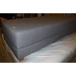 A grey fabric covered day bed on squat square tapered beech supports,