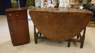 A 19th Century oak oval gate leg drop leaf dining table with two end drawers on turned supports to