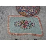 A needlework rug, the green ground set with floral spray within a tasselled edge approx.