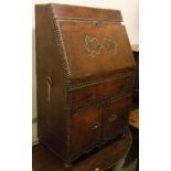 A studded brown leather covered bureau in the Spanish or Portugese taste,