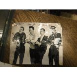 An unframed black and white photograph of The Shadows signed by all four members,