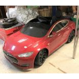 A child's battery operated Tesla toy car in red