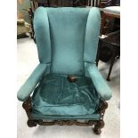 A circa 1900 upholstered wing back scroll armchair in the Flemish taste,