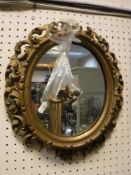 A 19th Century oval giltwood foliate carved framed wall mirror in the Florentine manner,