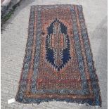 A Persian rug, the central medallion on a red ground with a red and blue stepped border approx.