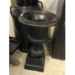 A black painted milk churn, approx 67 cm high, a black painted cast iron urn,