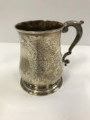 A George II silver baluster shaped mug with later engraved foliate decoration to the main body and